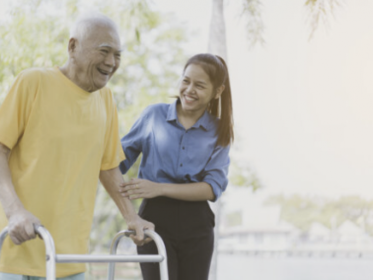 young woman interacting with older gentleman using a walker